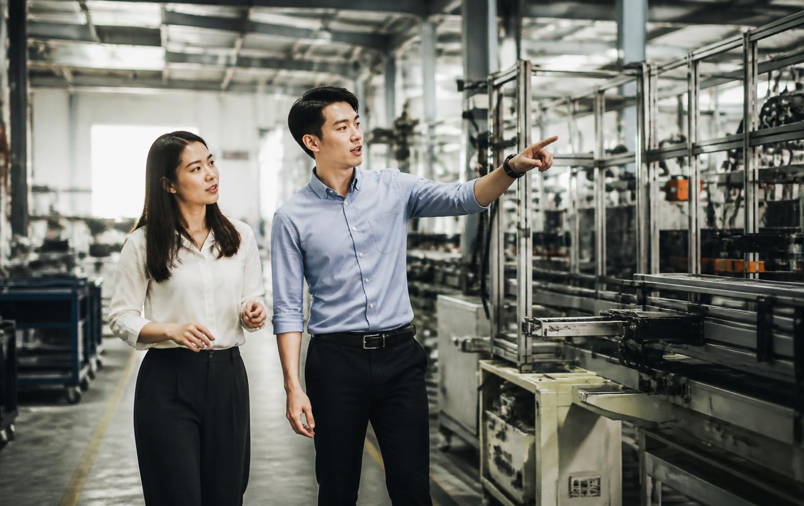 Two leaders walking through a manufacturing facility.