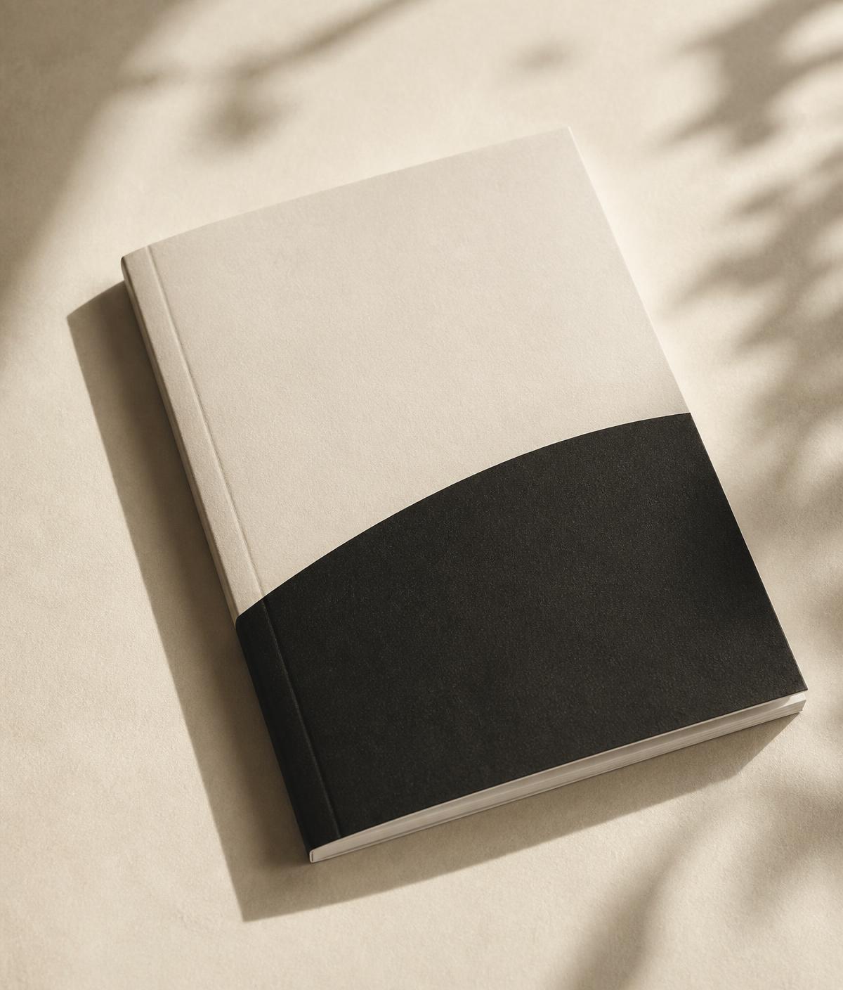 A printed journal resting on a warm ivory surface.
